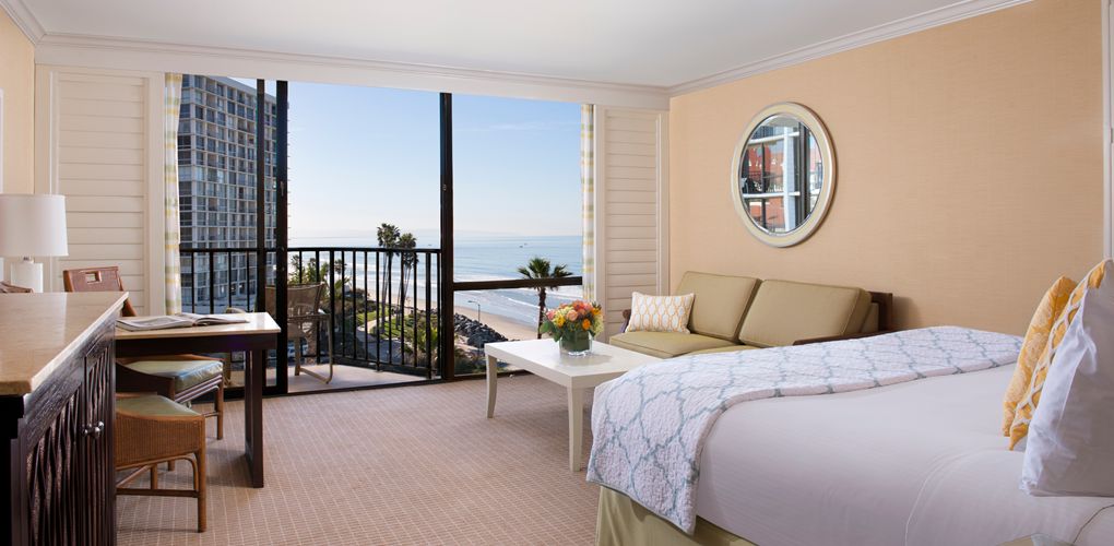 a bedroom with a balcony overlooking the ocean