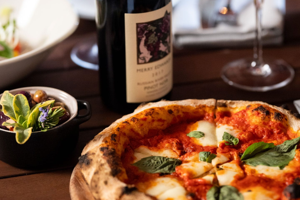 a pizza and a bottle of wine