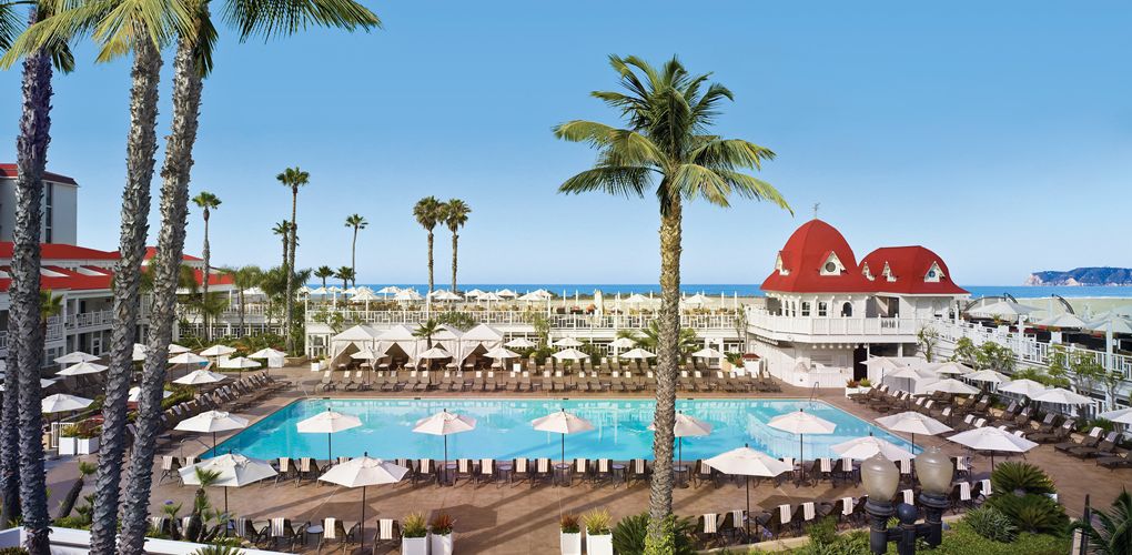 a pool with umbrellas and chairs and palm trees