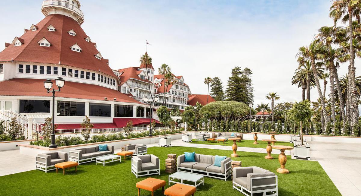 a large lawn with chairs and tables in front of a large building