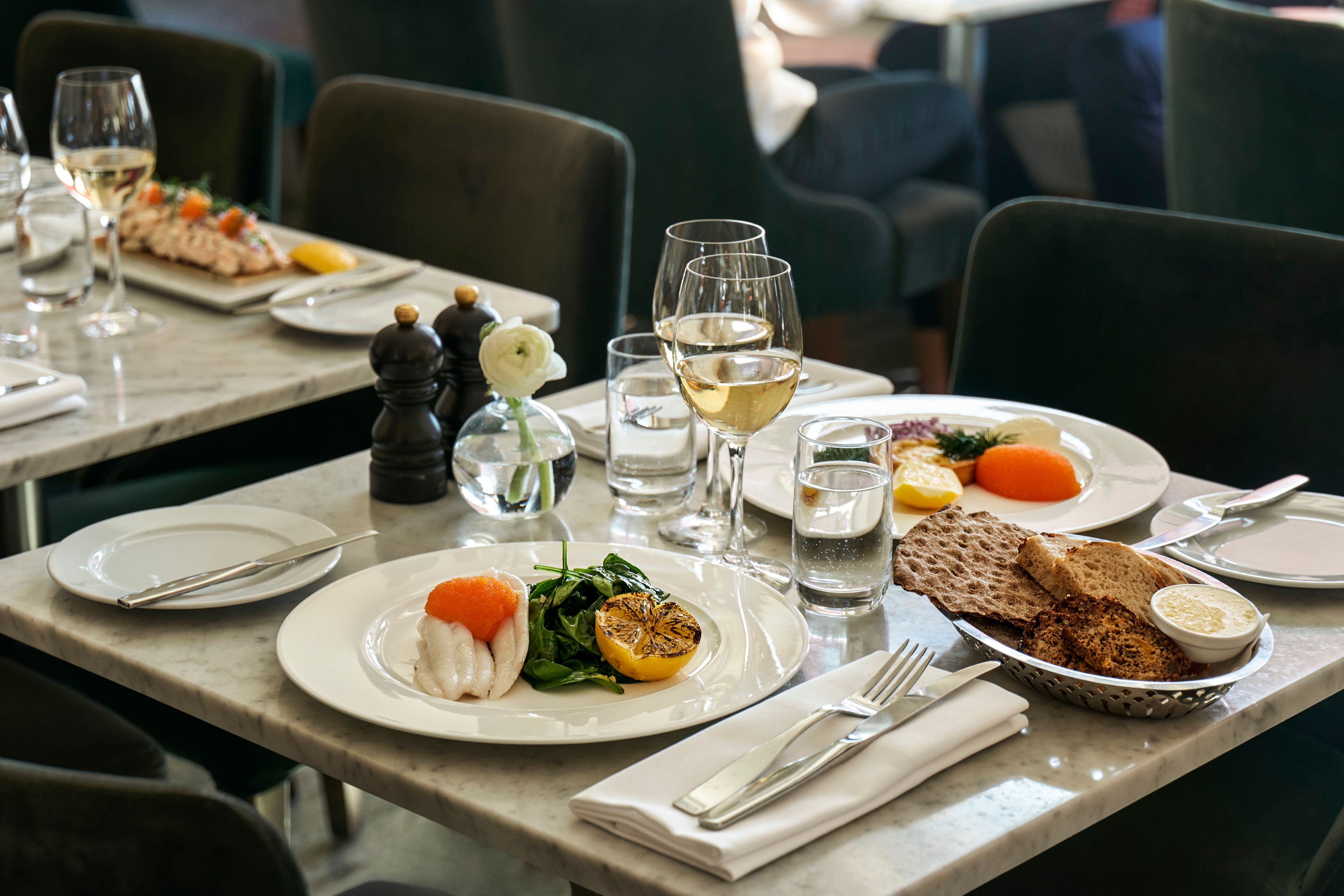 a table with plates of food and glasses of wine