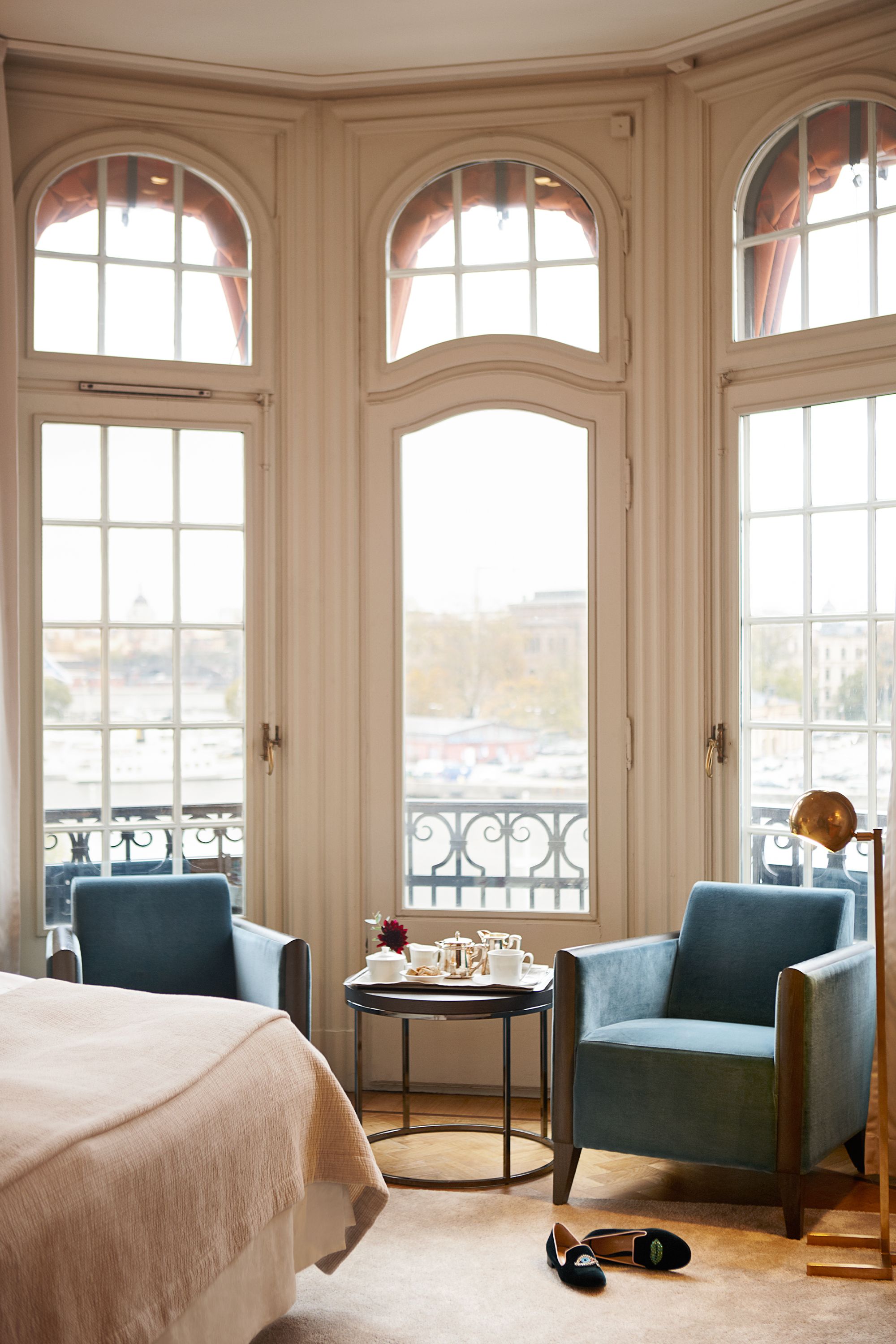 a room with a bed and chairs