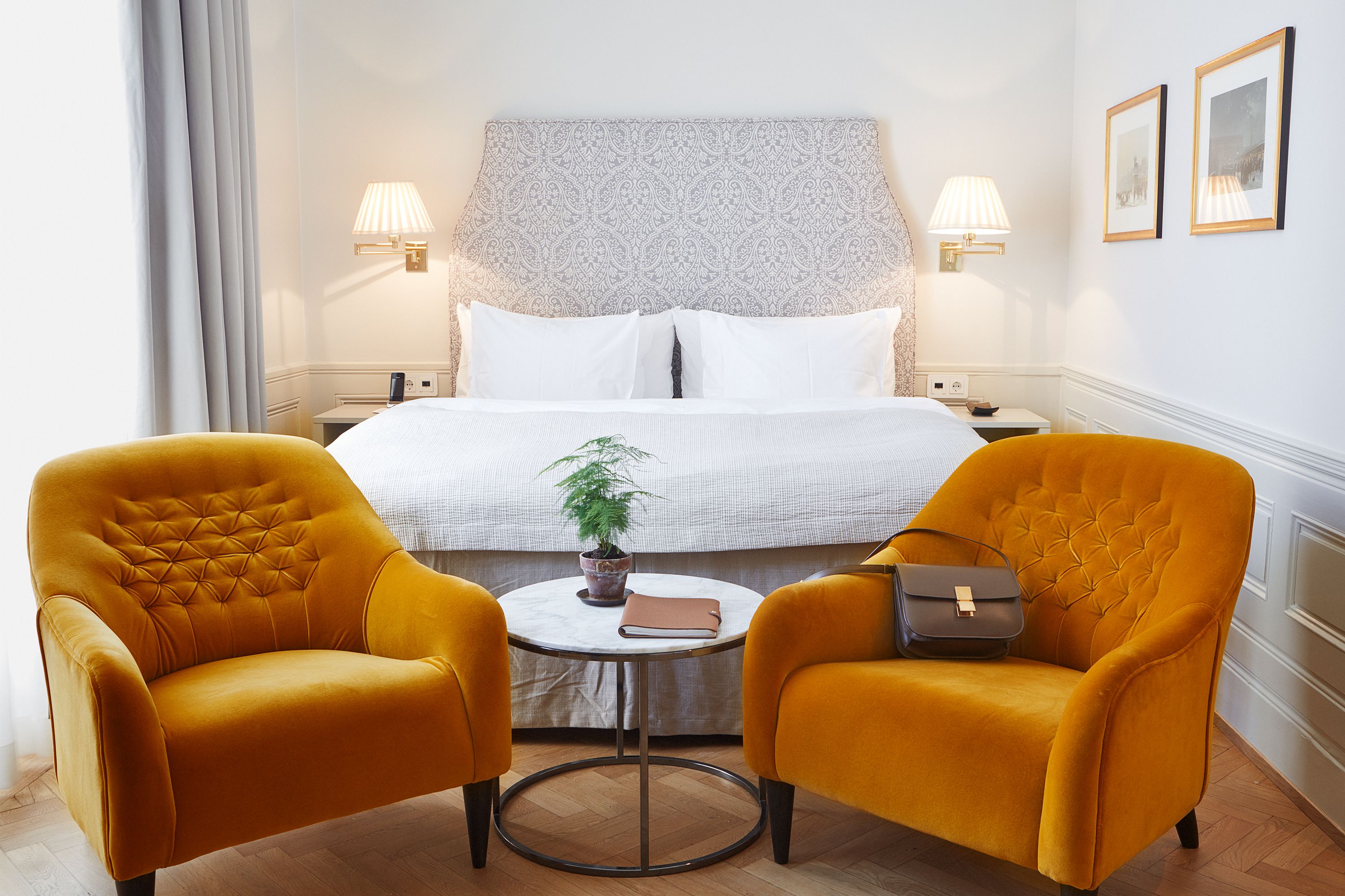 a room with a bed and two chairs