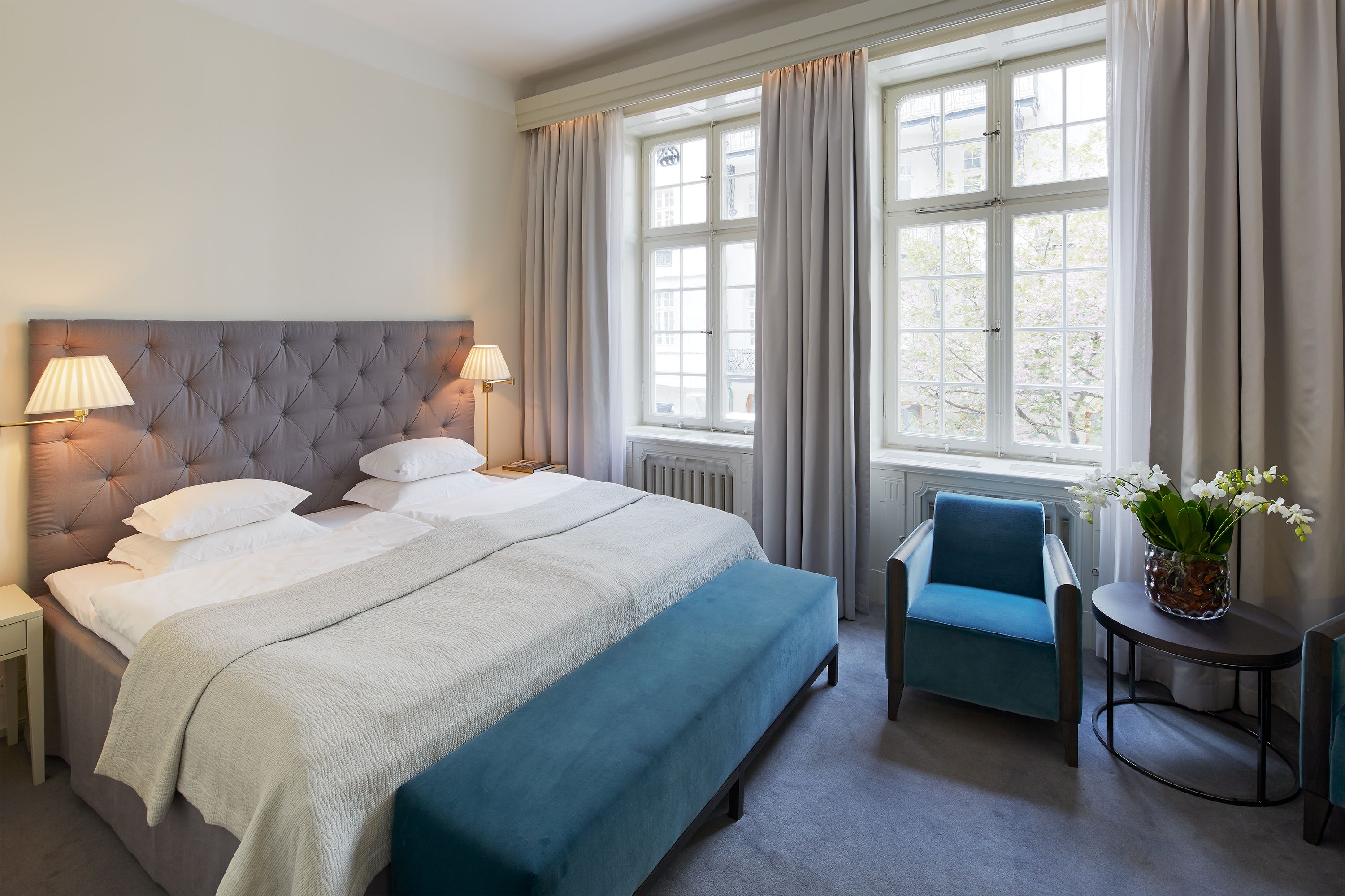a bed with a chair and a lamp in a room