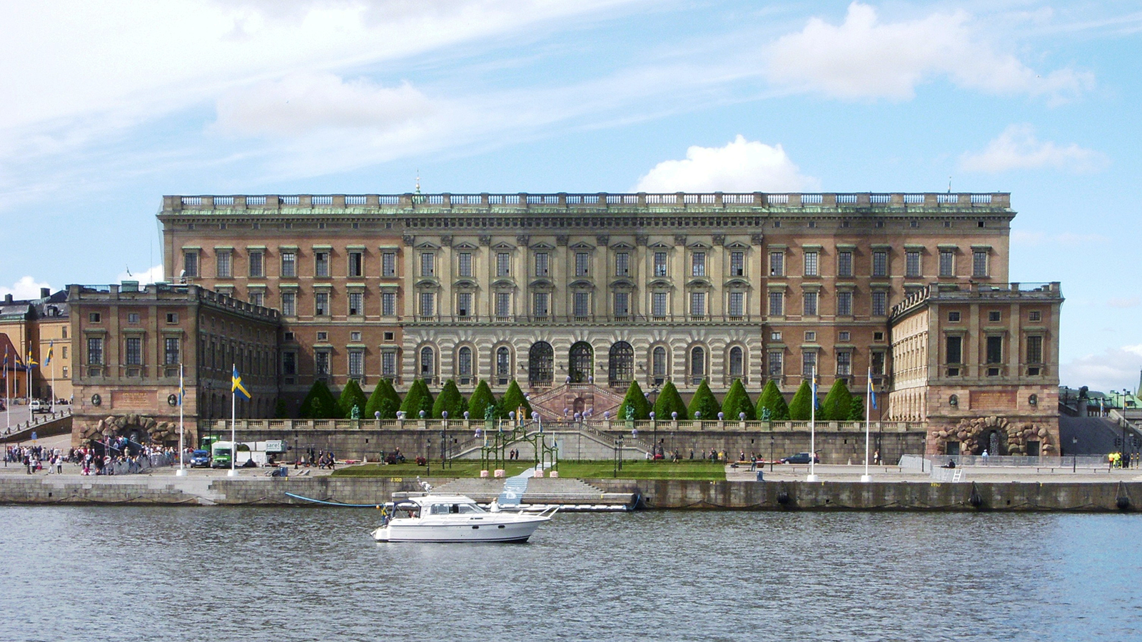 a large building with a boat in the water with Stockholm Palace in the background