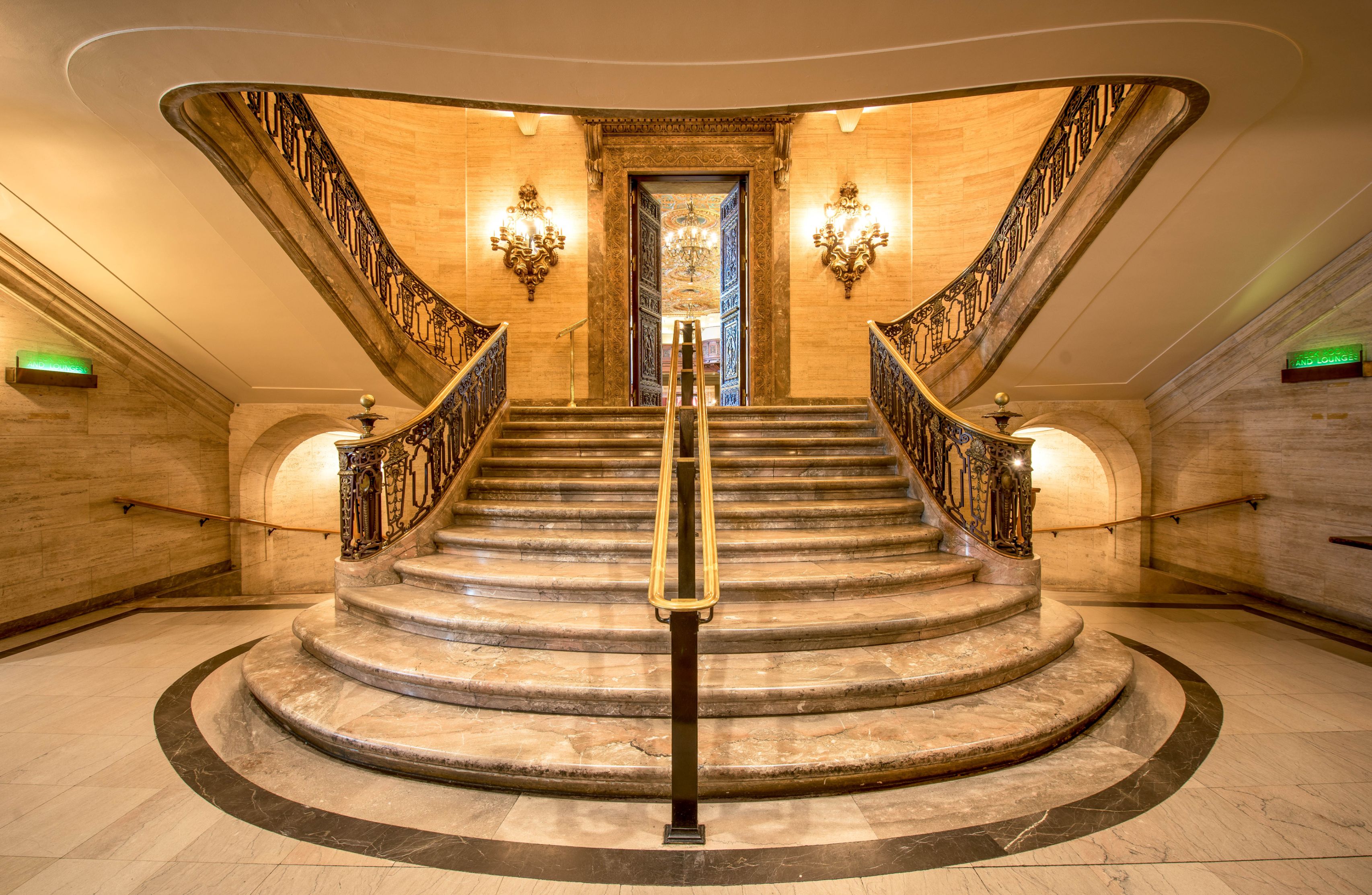 a marble staircase with wrought iron railings