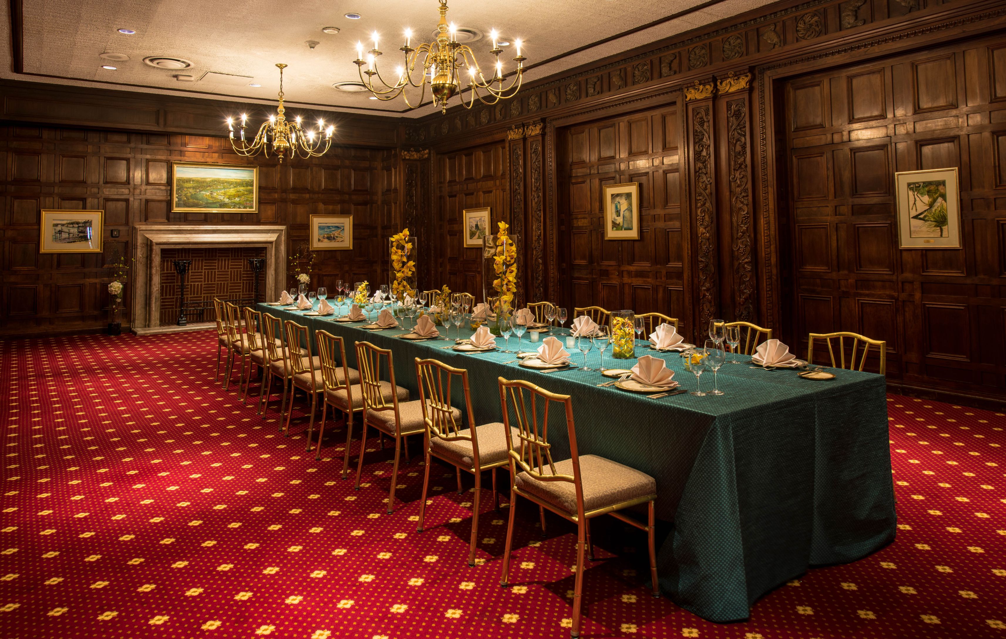 a long table with chairs and chandeliers