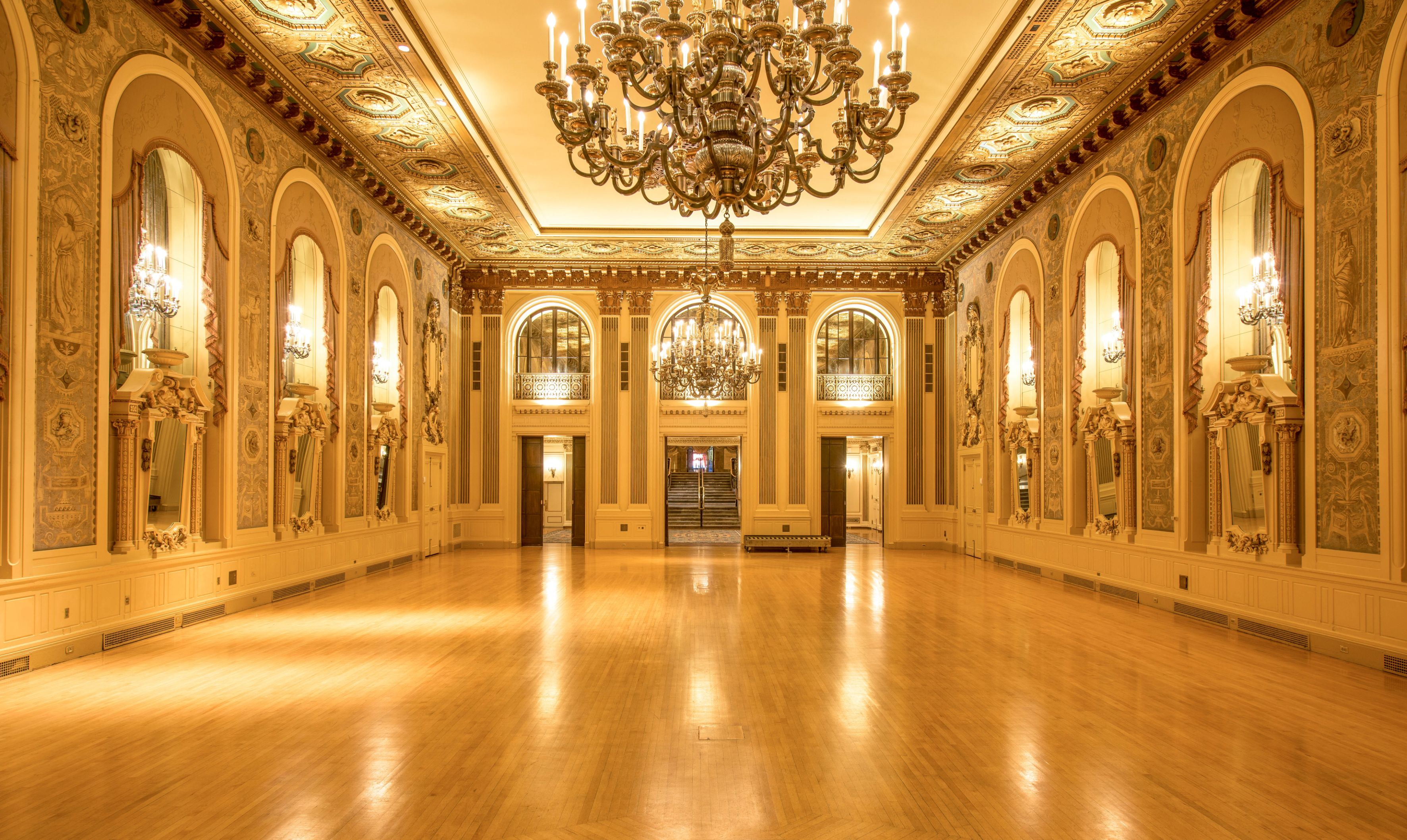 a large room with chandelier and wood floors