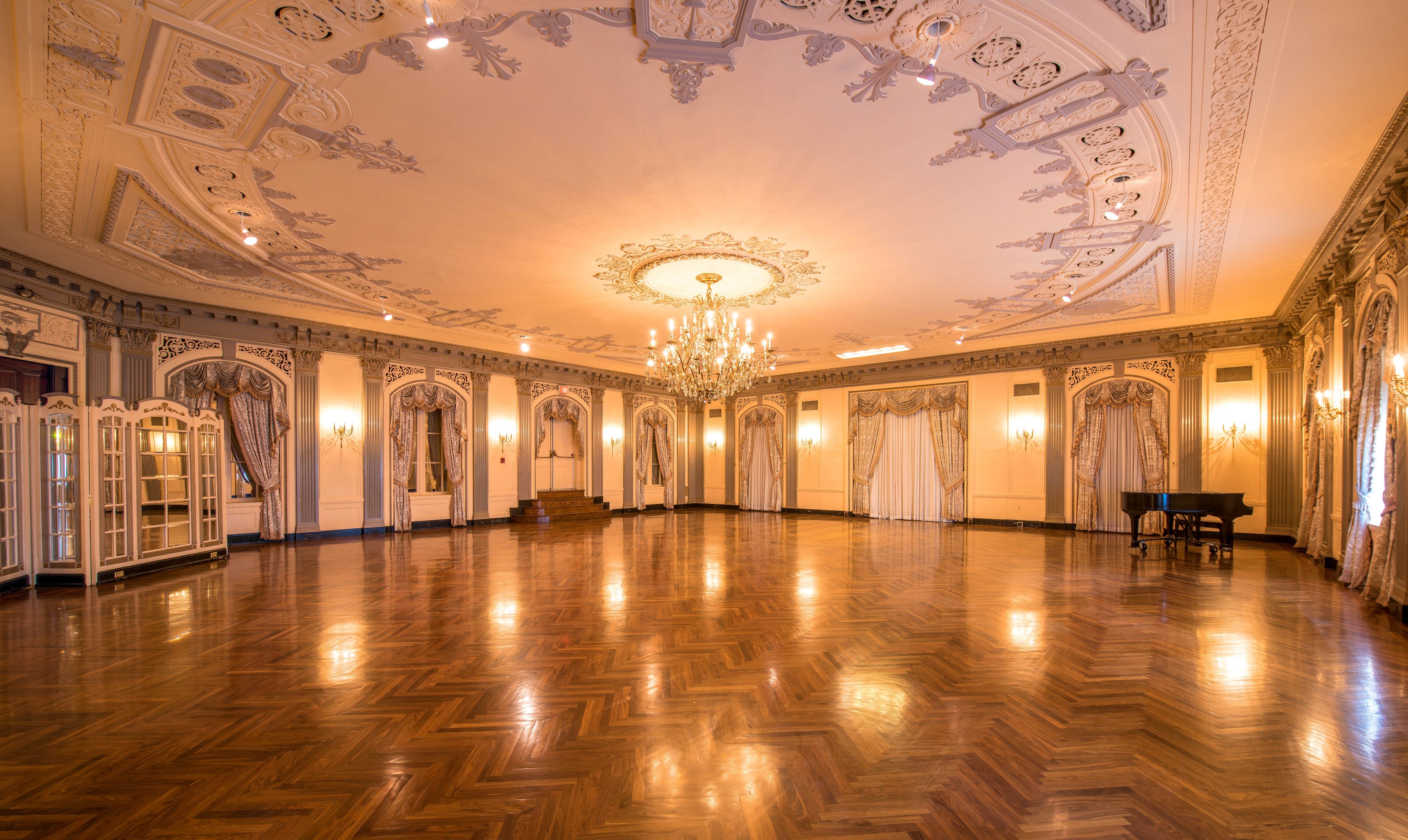 a large room with a chandelier and a wood floor