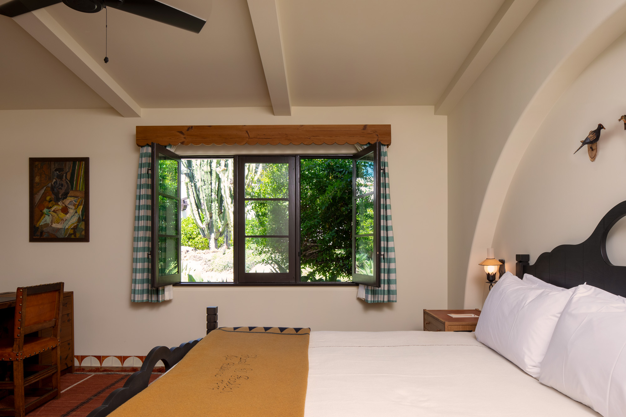 a bed with a window and a fan