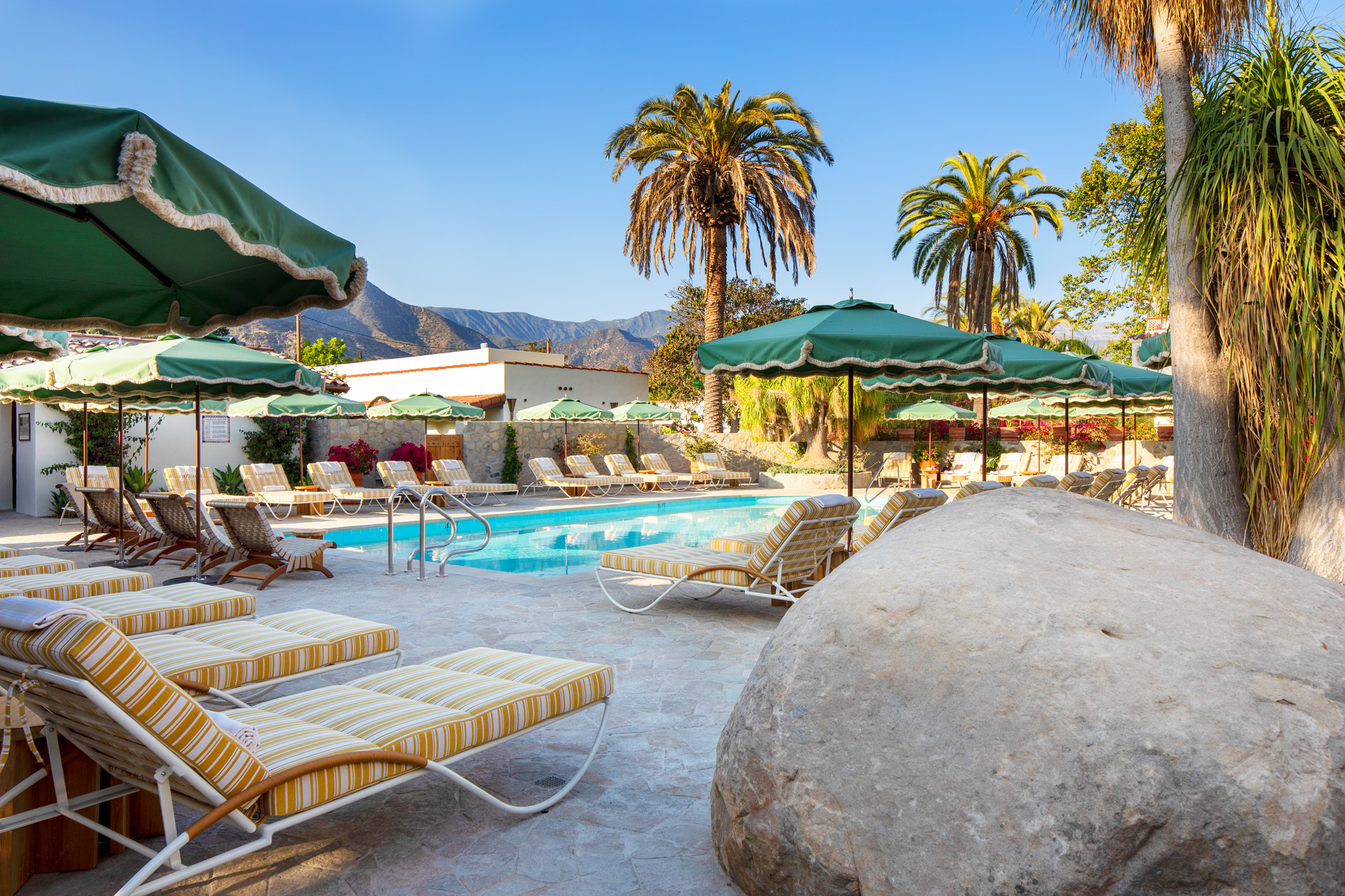 a pool with lounge chairs and umbrellas