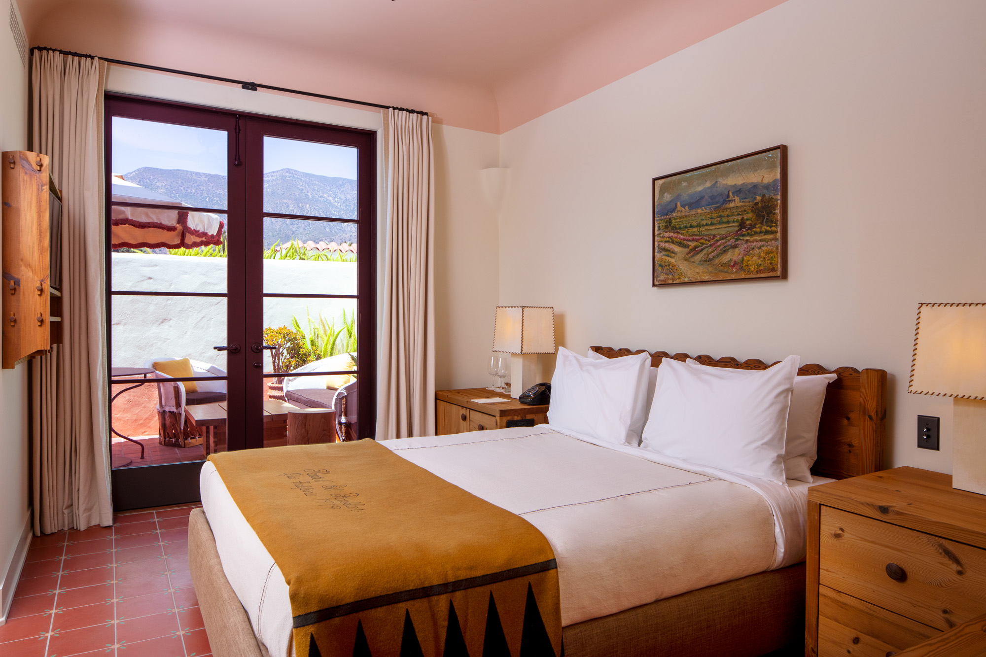 a bed with a glass door and a picture of a landscape