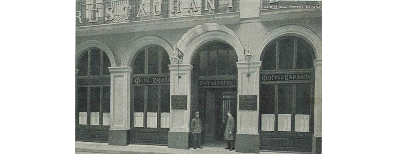 a couple of men standing outside of a restaurant