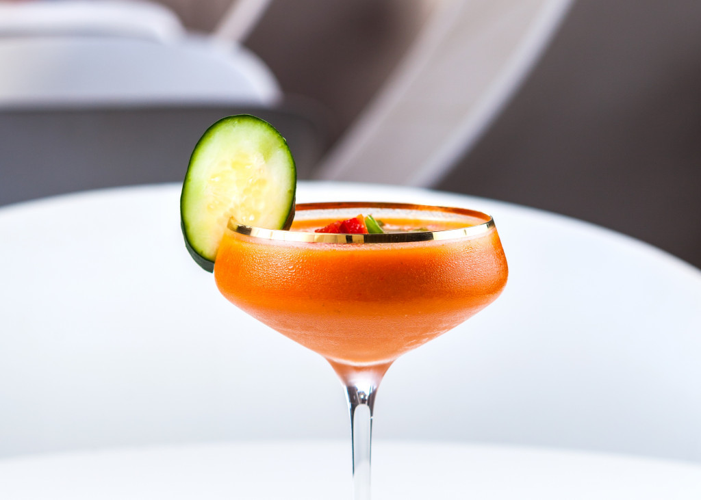 a glass with a drink and a cucumber slice on it