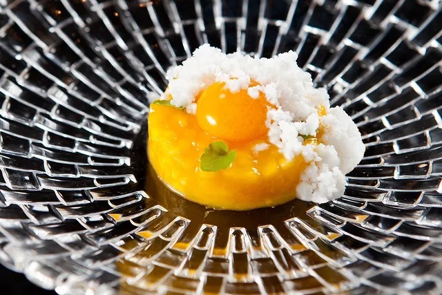 a plate of food with a yolk and white flakes