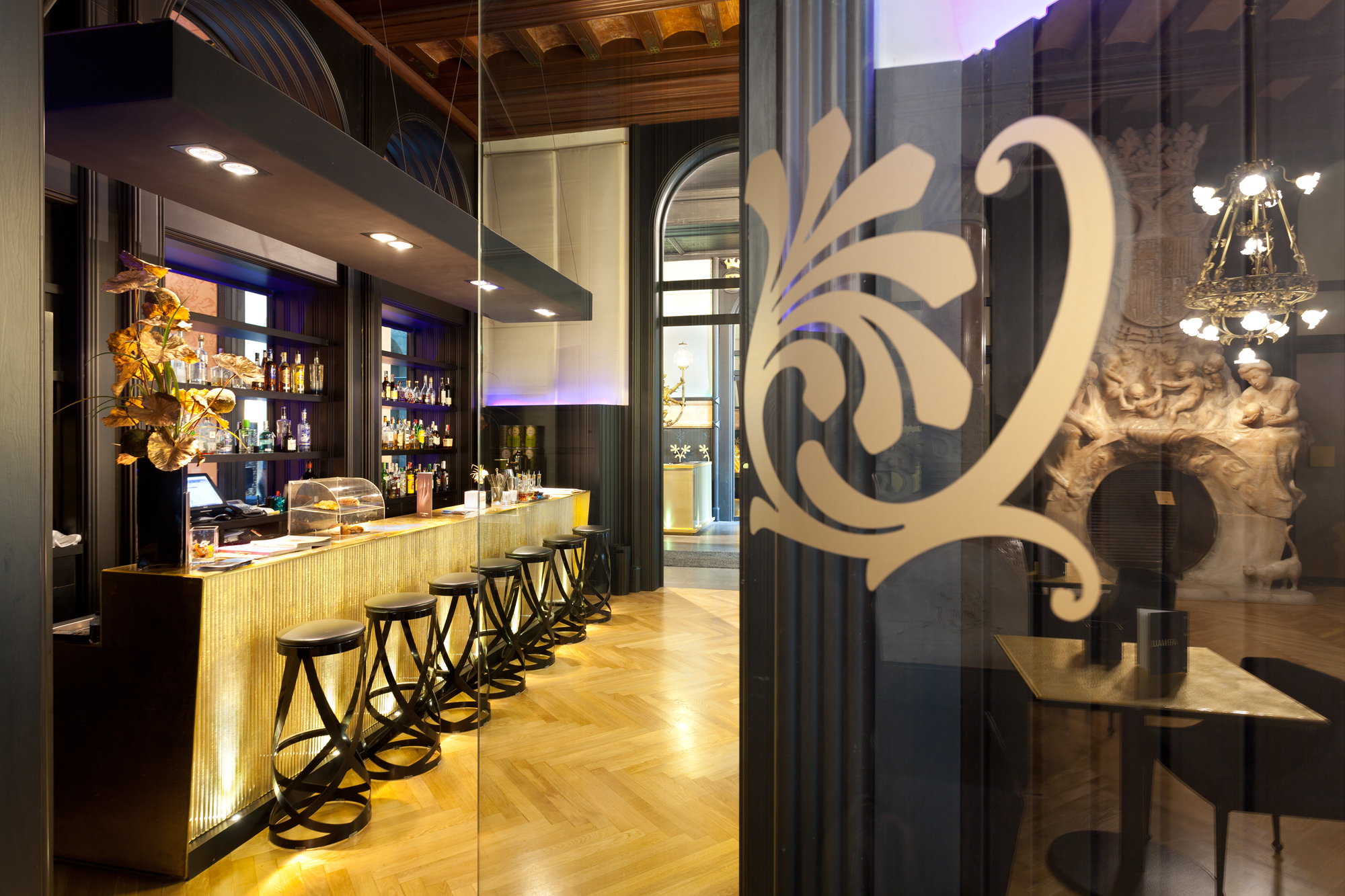 a bar with stools and a glass wall