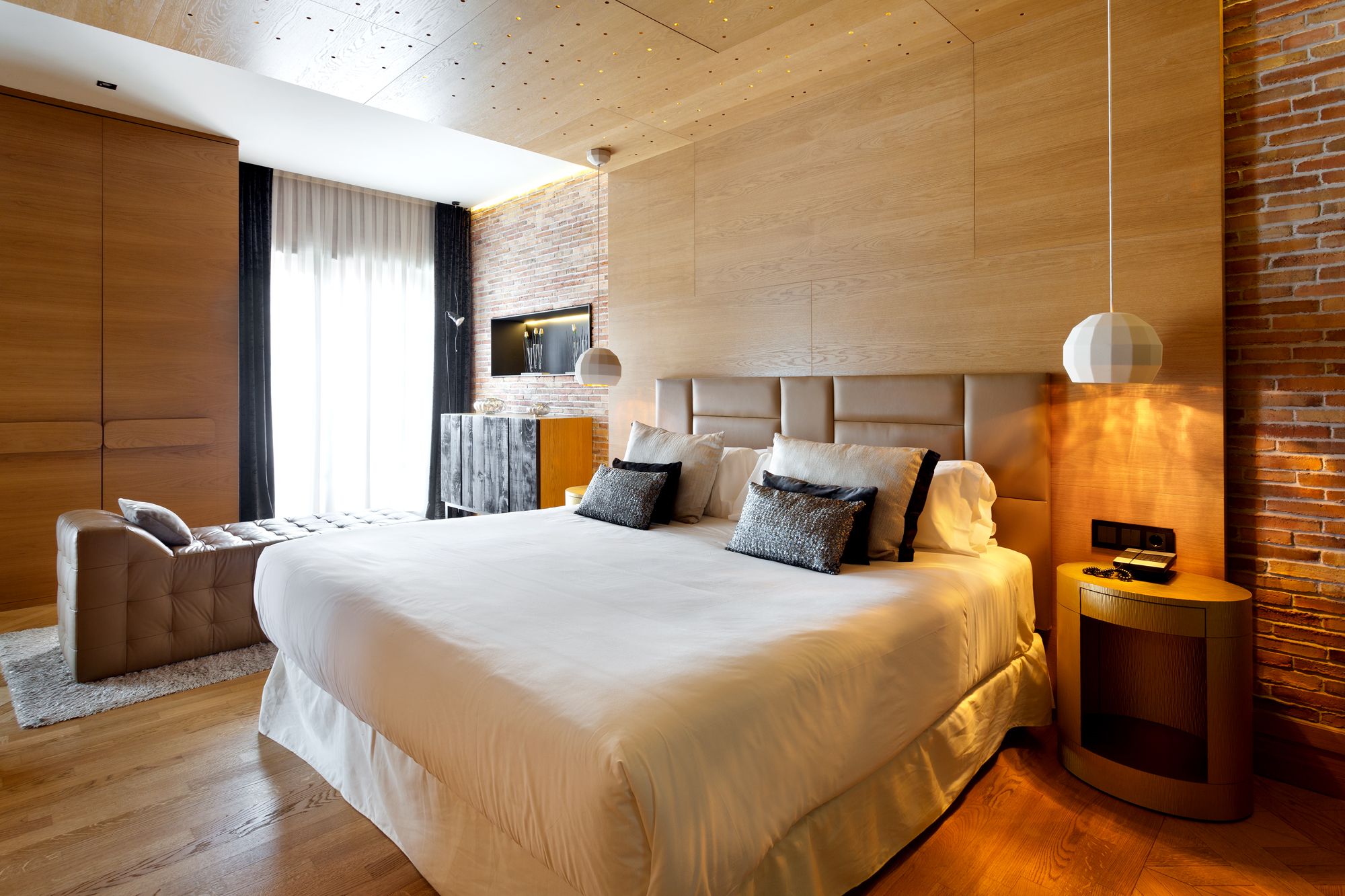a bed with white sheets and pillows in a room