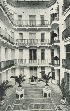 a courtyard with balconies and palm trees