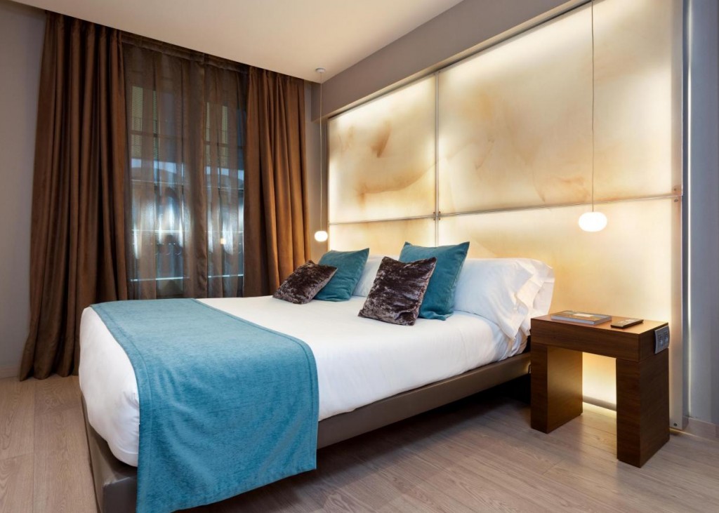 a bed with blue blanket and pillows in a room