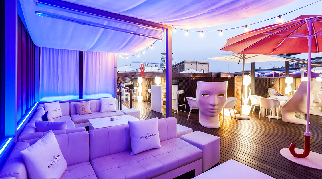 a patio with a large head sculpture and a table