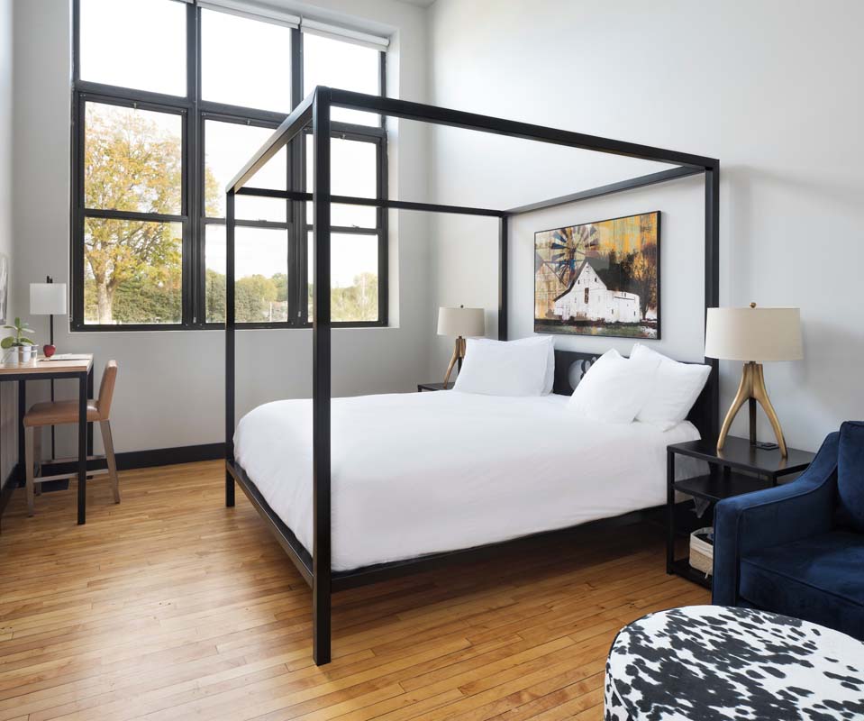 a bedroom with a four poster bed and a chair