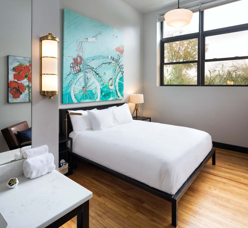 a room with a bed and artwork