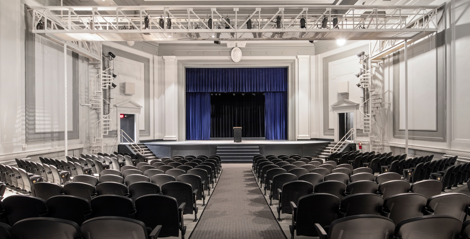 a theater with a stage and blue curtain