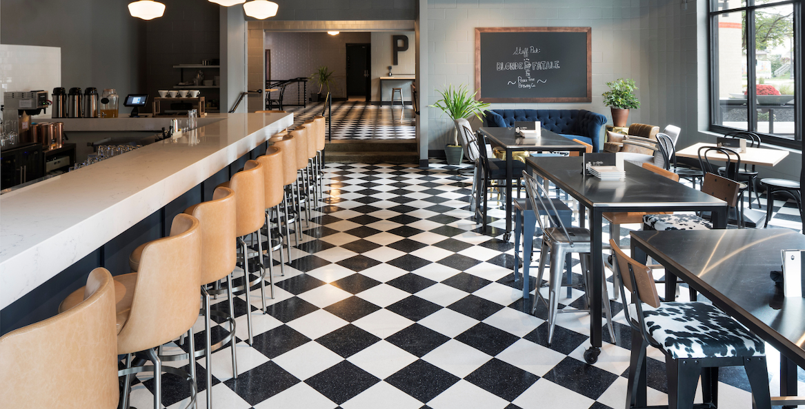 a black and white checkered floor with tables and chairs