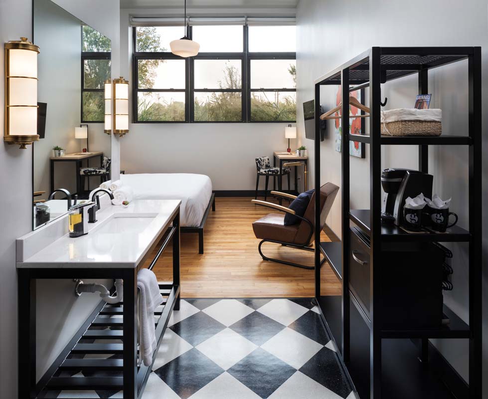 a room with a bed and a black and white checkered floor