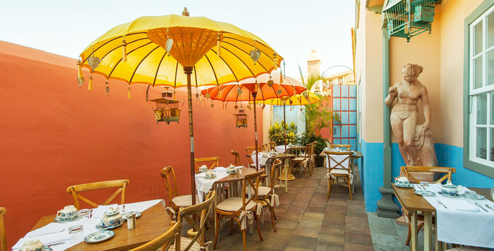 a tables and chairs with umbrellas