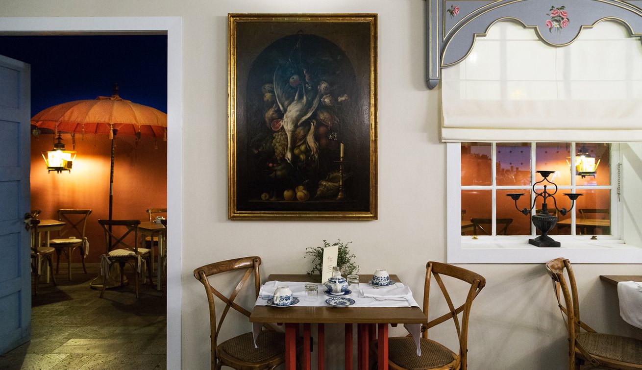 a table and chairs with a painting on the wall