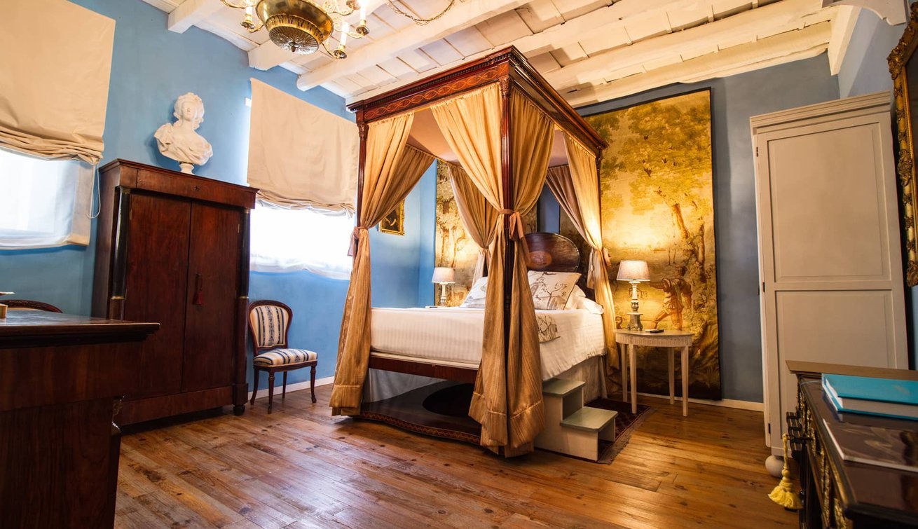 a room with a canopy bed and a chair