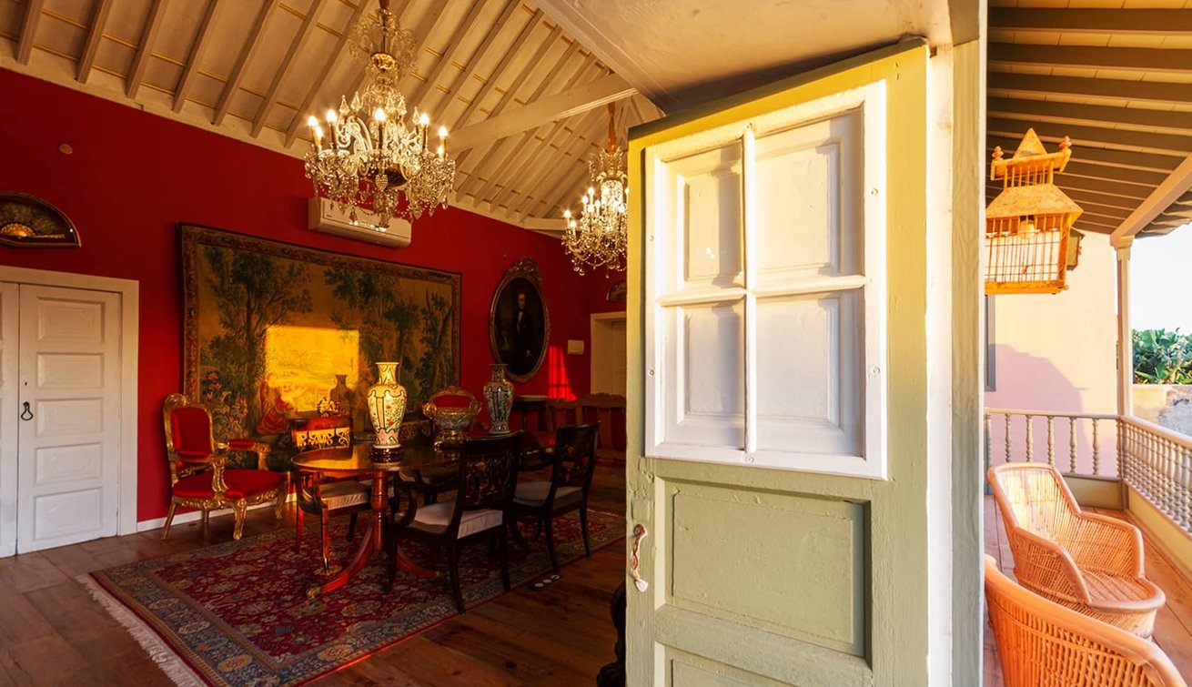 a room with a dining table and chandeliers
