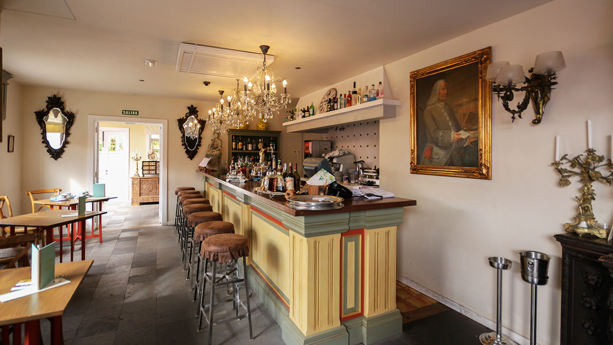 a bar with stools and a chandelier