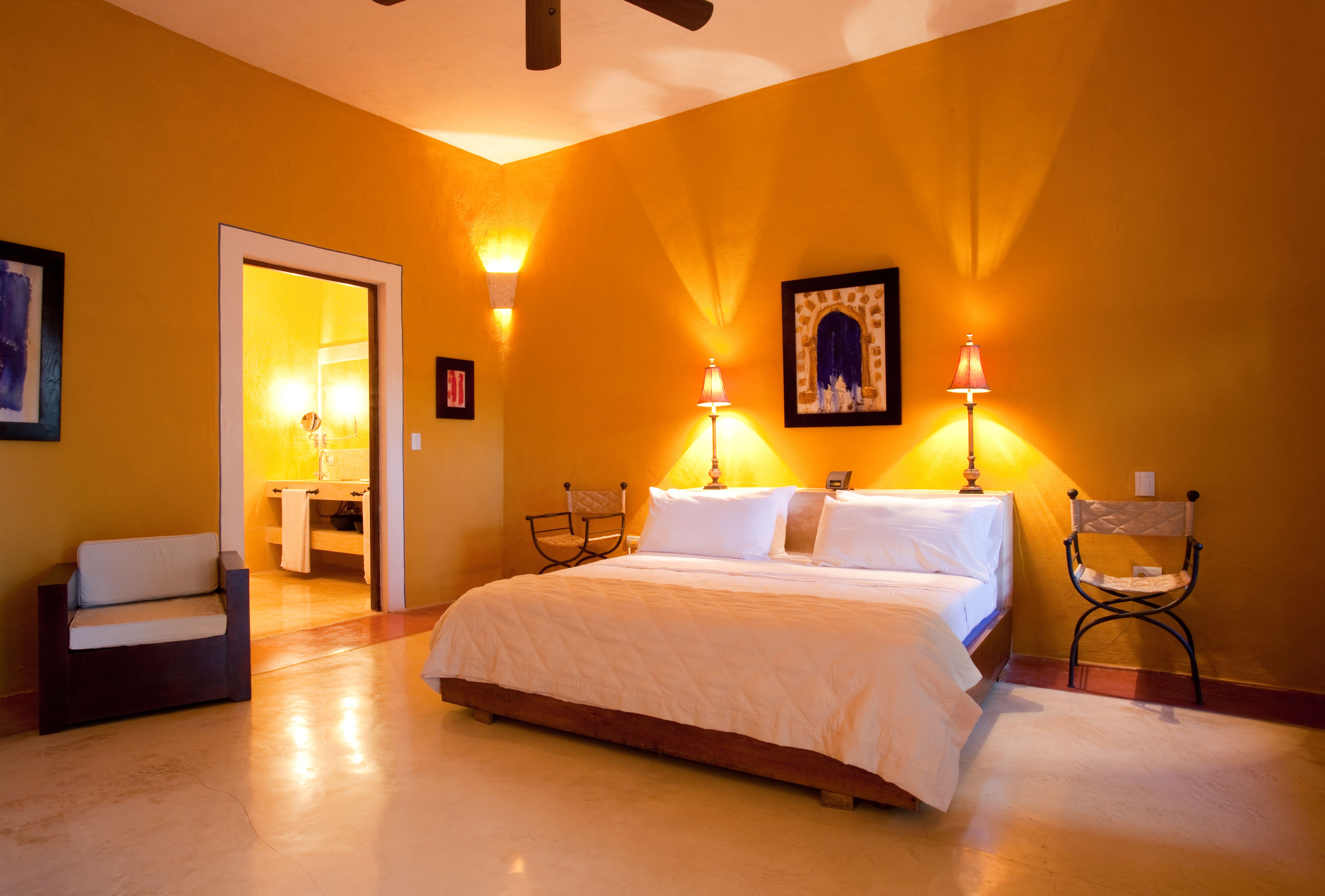 a bed with two lamps on the wall