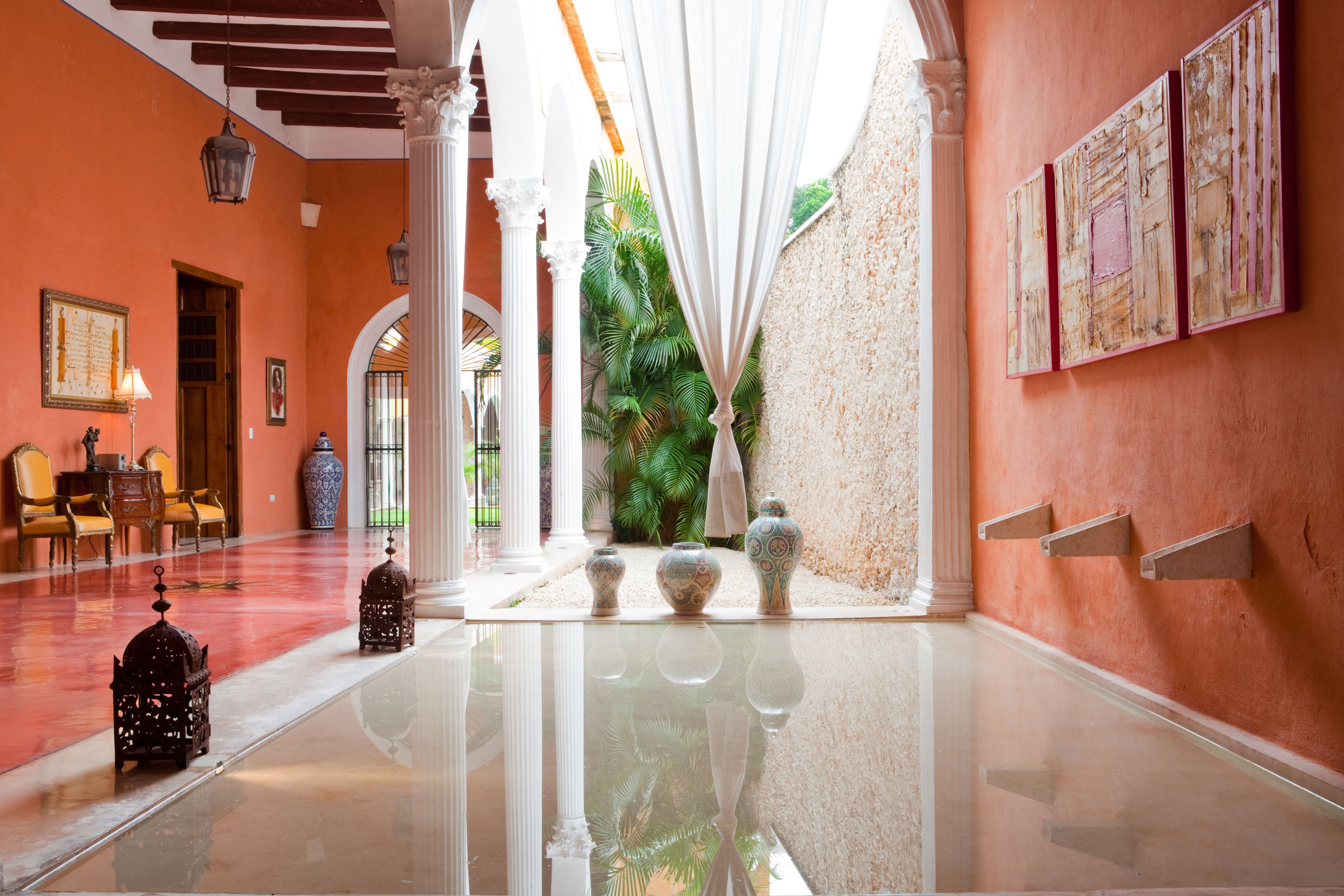 a hallway with white pillars and vases