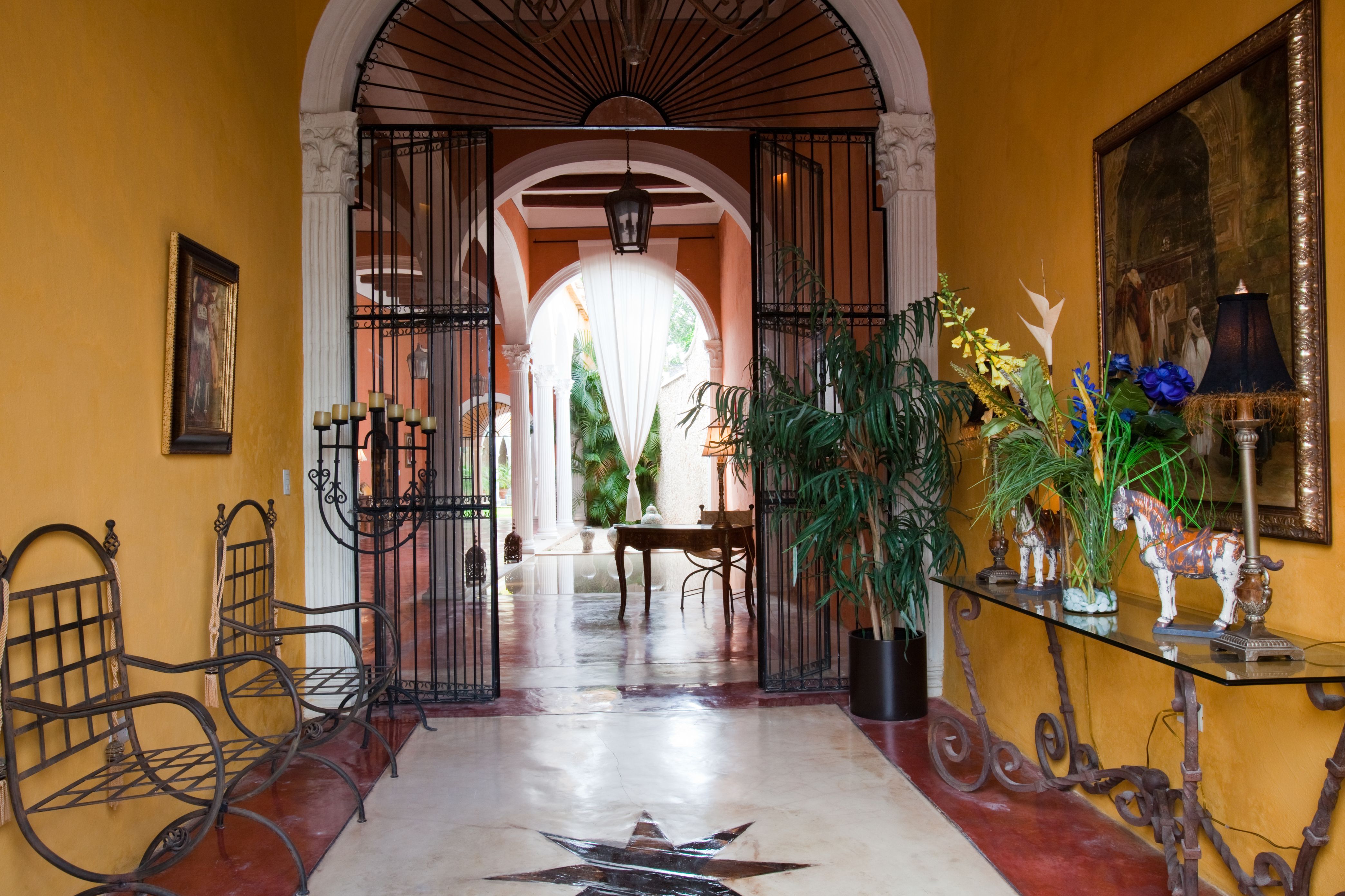 a hallway with iron gates and plants
