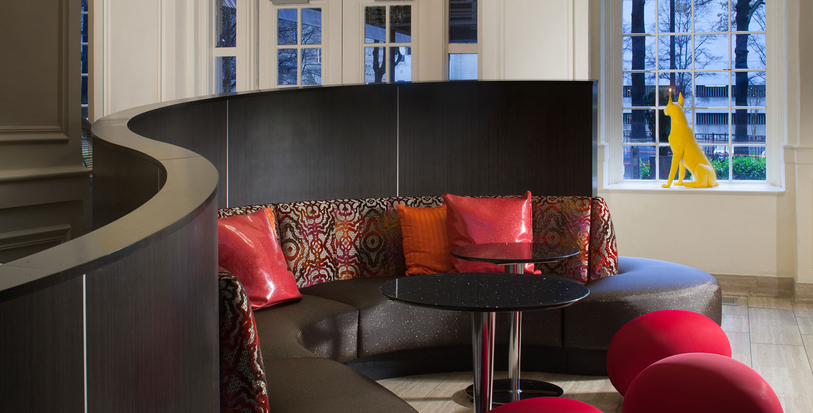 a couch with red pillows and a round table