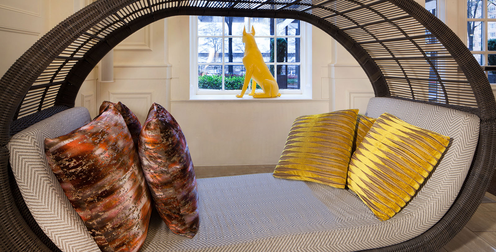 a yellow dog statue sitting on a window sill