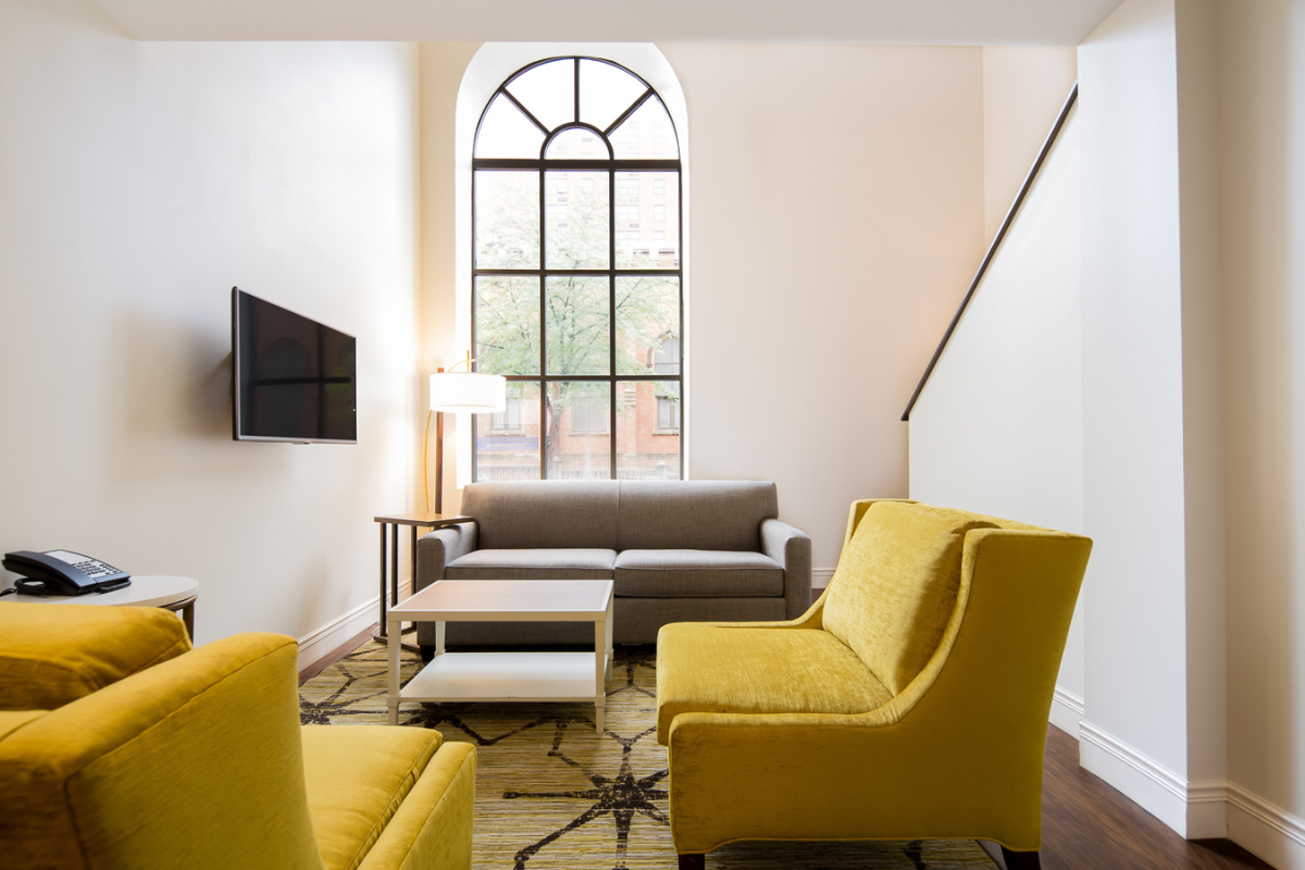 a room with yellow chairs and a tv