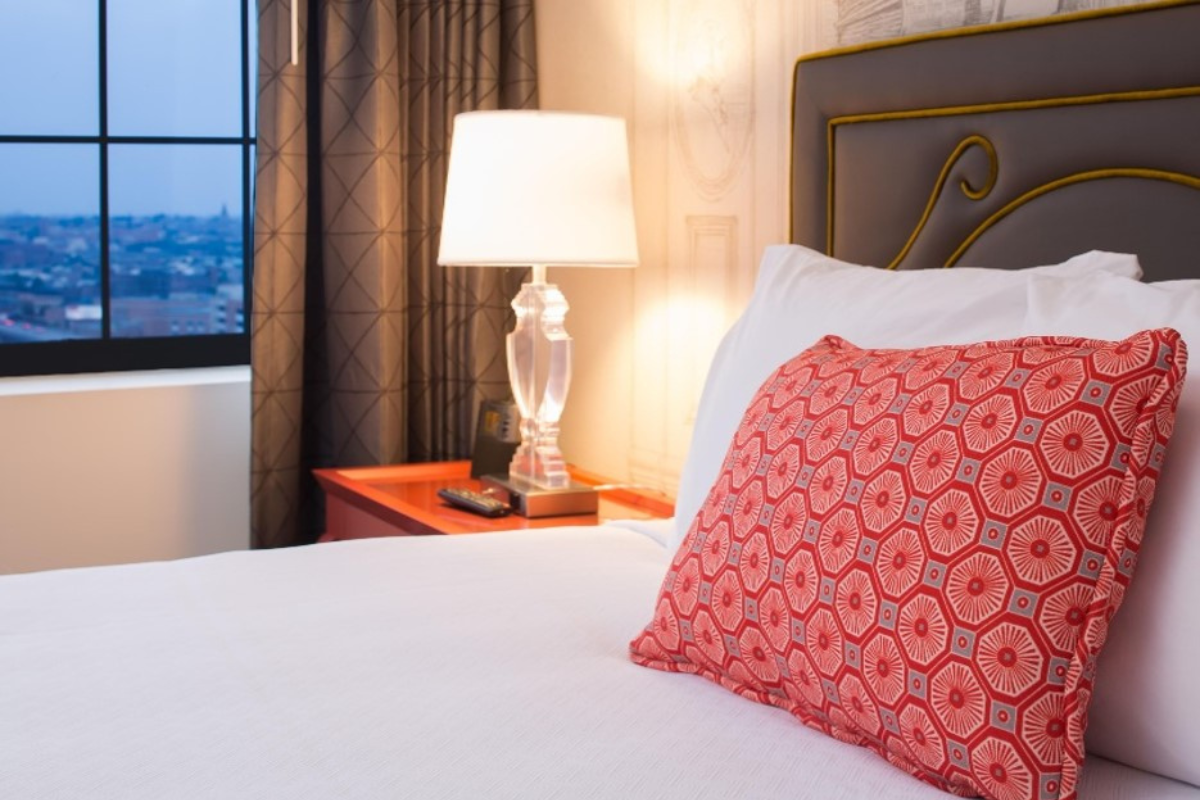 a bed with a lamp and a window