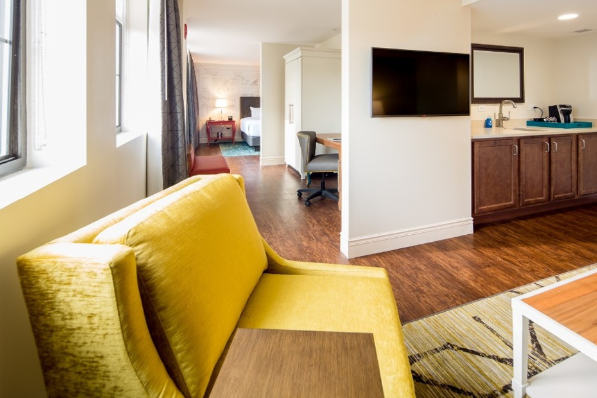 a room with a yellow couch and a tv