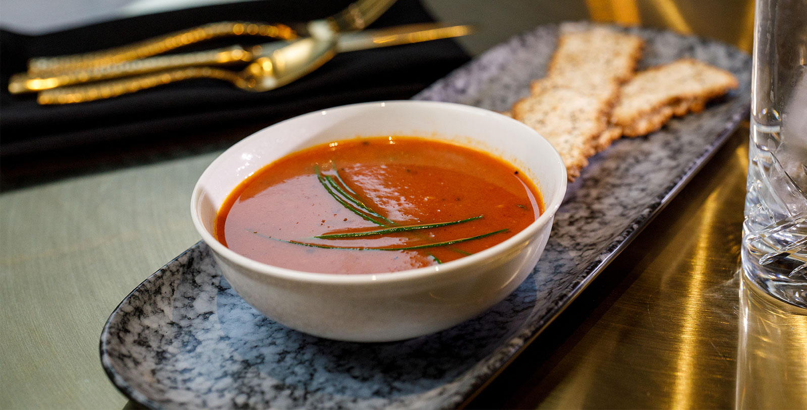 a bowl of soup with a piece of bread on a plate