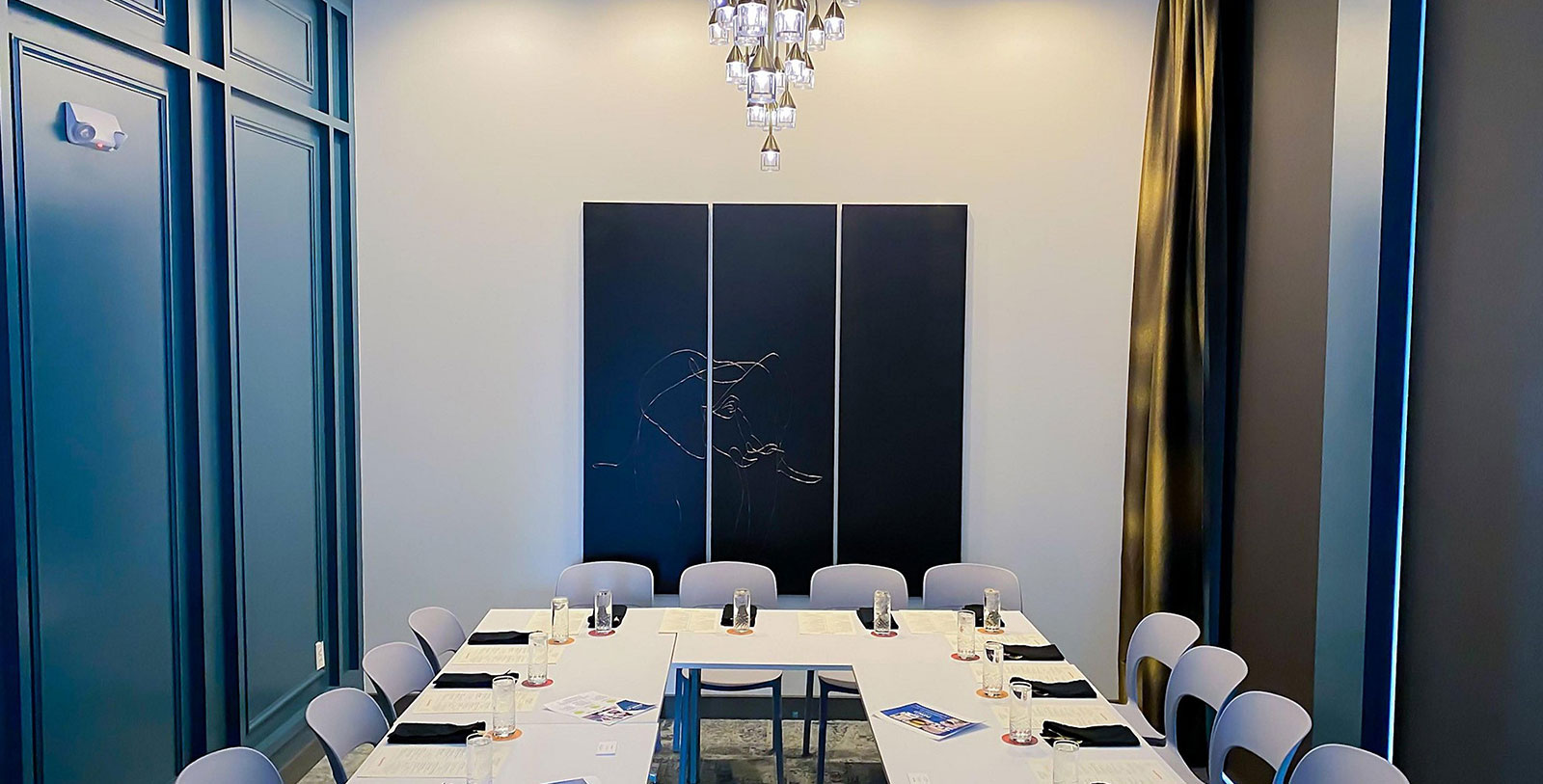 a room with a chandelier and a table with chairs