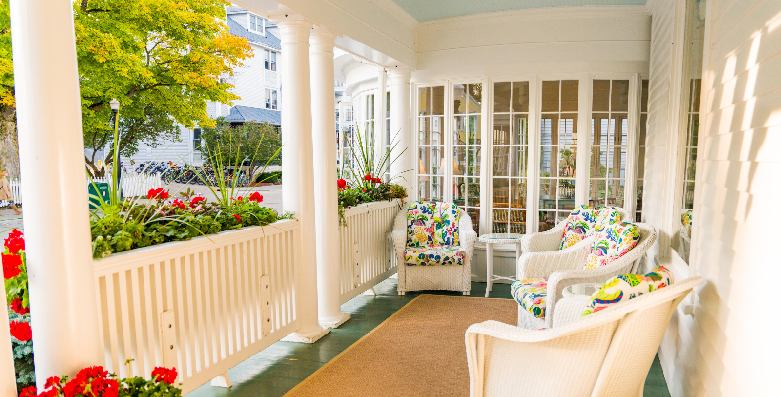 a white porch with chairs and a rug
