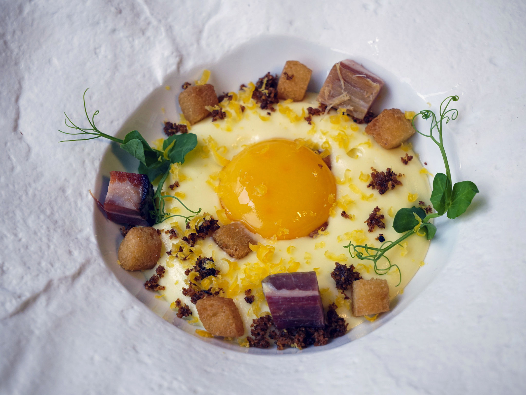 a plate of food with a yolk and some meat