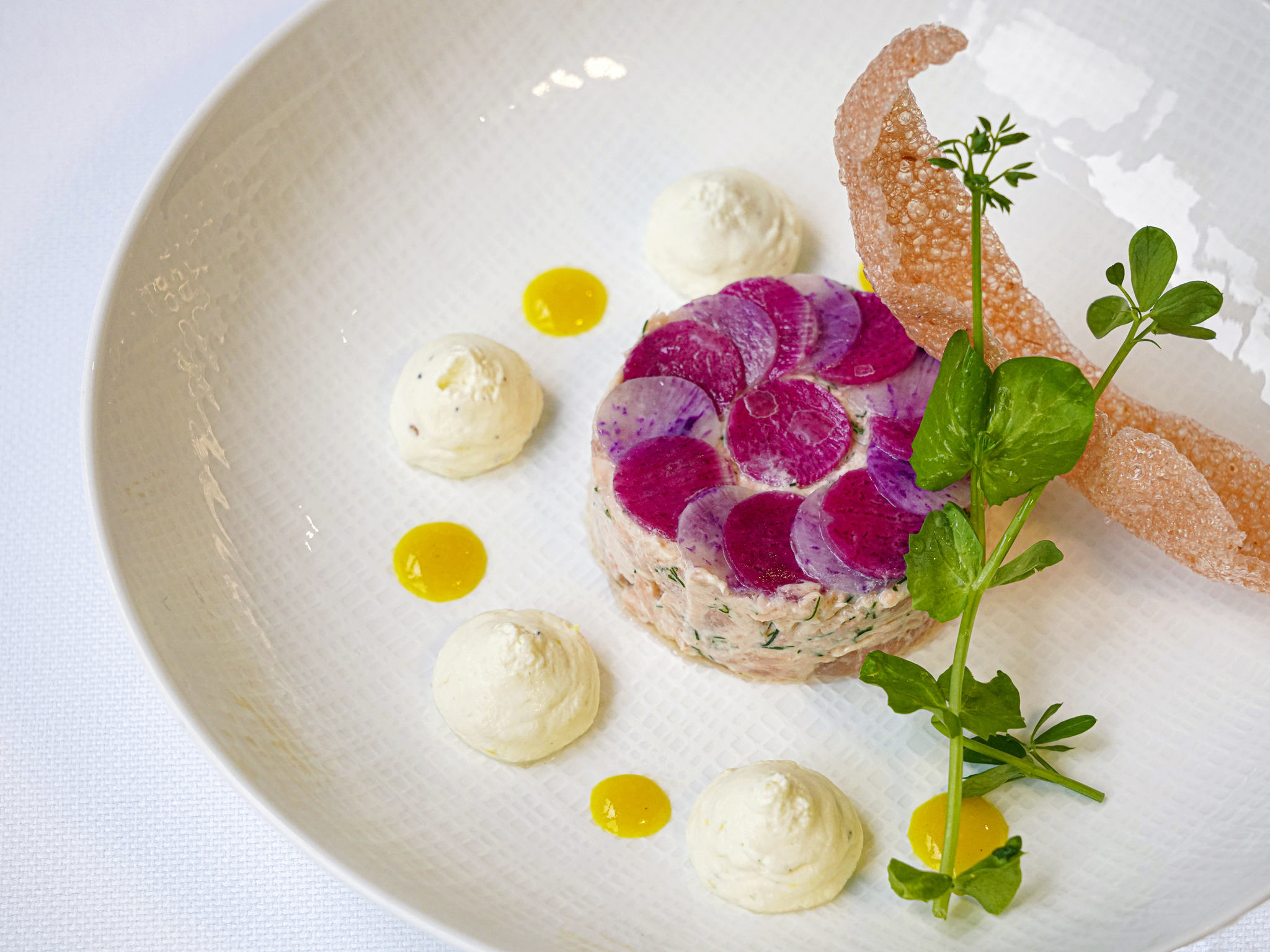 a plate of food with sauces and herbs
