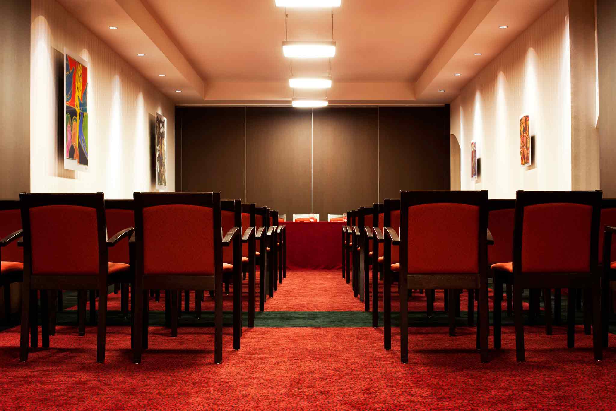a room with red carpet and chairs