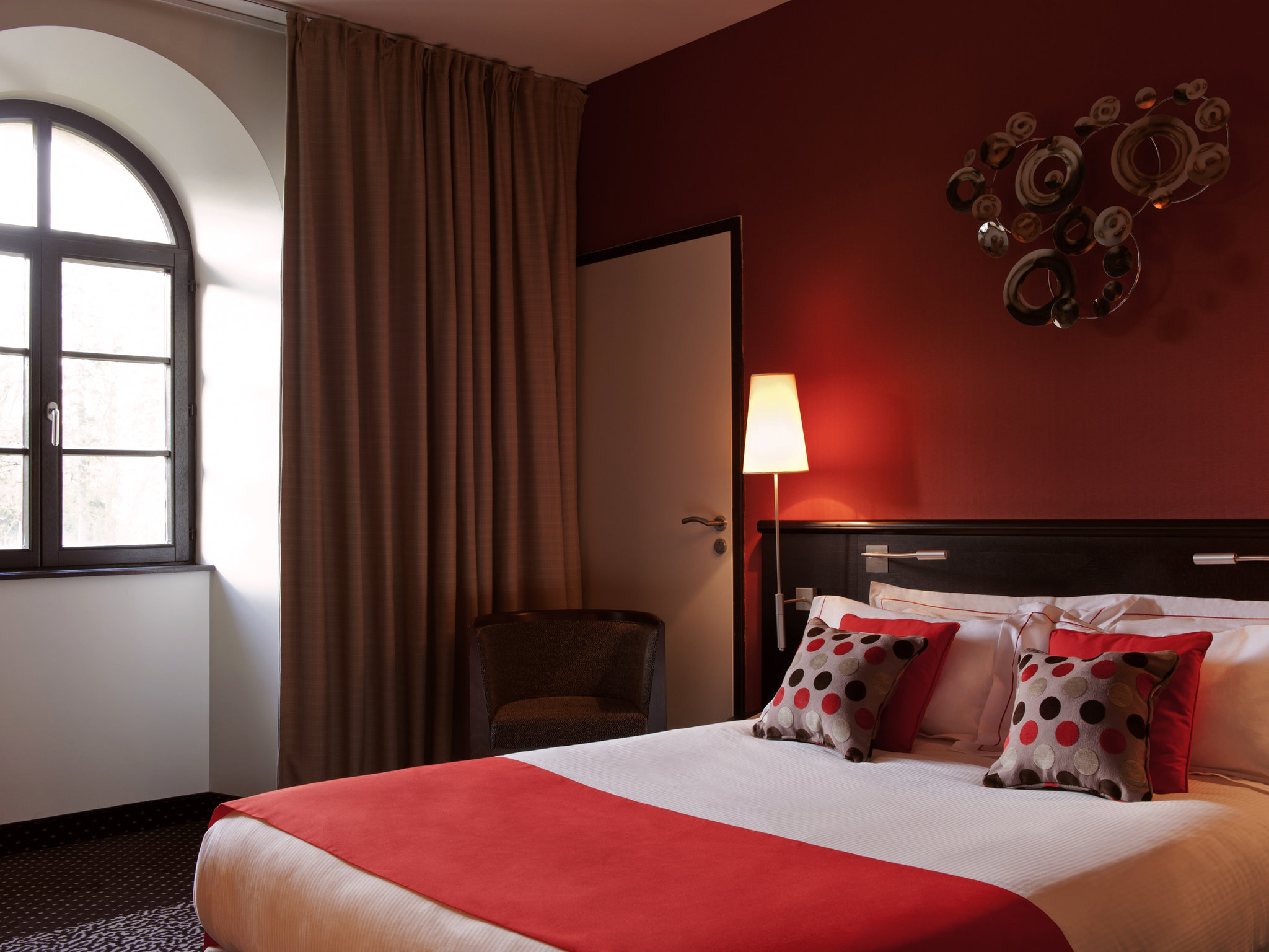 a bed with red and white pillows