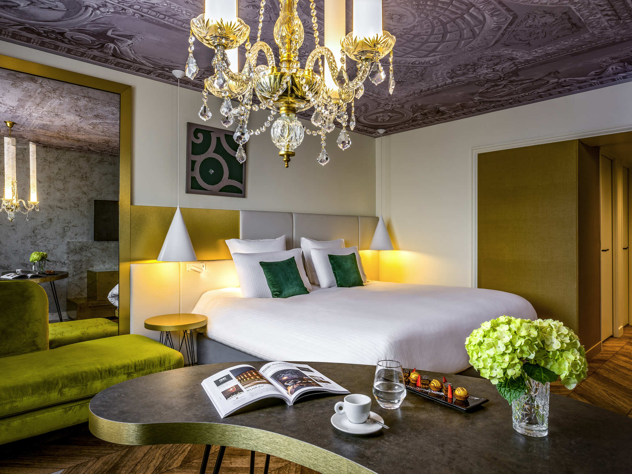 a room with a bed and a table with a chandelier